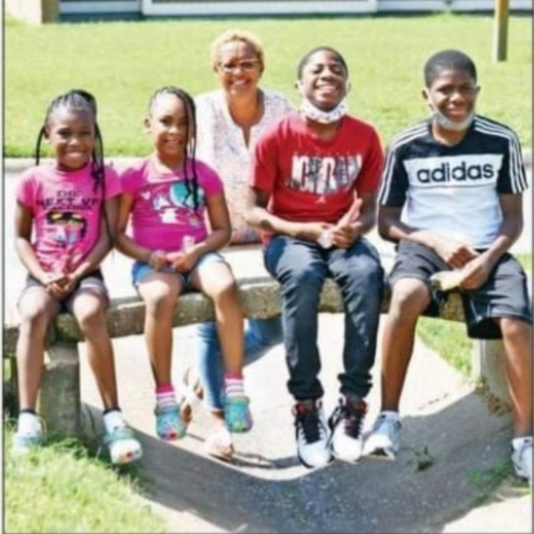Group of children and adult outdoors in a sunny park